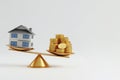 Libra with a house on one bowl and coins on the other. Space for text. Royalty Free Stock Photo
