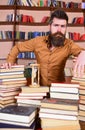 Librarian concept. Teacher, scientist with beard stands at table with books, defocused. Man on thoughtful face stands Royalty Free Stock Photo