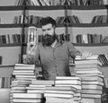 Librarian concept. Teacher, scientist with beard stands at table with books, defocused. Man on thoughtful face stands Royalty Free Stock Photo