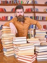 Librarian concept. Teacher or student with beard stands at table with books, defocused. Man on thoughtful face stands Royalty Free Stock Photo