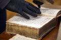 Librarian in gloves holds a rare book