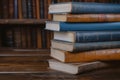 Library essentials stack of books over wooden table for education