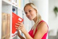 Pretty female student with books working in a high school library Royalty Free Stock Photo