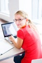 In the library - pretty, female student with books and laptop Royalty Free Stock Photo