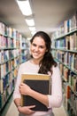 In the library - pretty female student with books working in a h