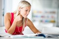 Pretty female student with books working in a high school library Royalty Free Stock Photo