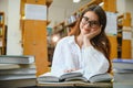 in the library - pretty female student with books working in a high school library. Royalty Free Stock Photo