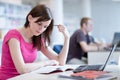 In the library - pretty female student with laptop and books Royalty Free Stock Photo