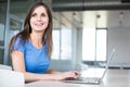 In the library - pretty female student with laptop and books Royalty Free Stock Photo