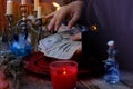 Librate with money, female hands of psychic doing witchcraft passes with dollars, esoteric Oracle performs ritual of removing