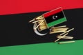 Libya flag is shown on an open matchbox, from which several matches fall and lies on a large flag