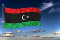 Libya national flag waving in the wind against deep blue sky. International relations concept