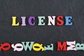 LICENSE word on black board background composed from colorful abc alphabet block wooden letters, copy space for ad text. Learning