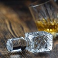 lid from a crystal decanter close-up on a wooden table. a glass of whiskey in the background Royalty Free Stock Photo