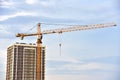 LIEBHERR tower crane constructing a new residential building at a construction site on blue sky background. Royalty Free Stock Photo