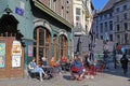 View on old ancient building in historical center, people sitting outside typical street cafe on sunny day Royalty Free Stock Photo