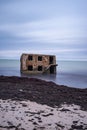 Liepaja beach bunker. Brick house, soft water, waves and rocks. Abandoned military ruins facilities in a stormy sea.