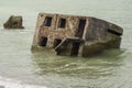 Liepaja beach bunker. Brick house, soft water, waves and rocks. Abandoned military ruins facilities in a stormy sea.