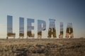 Liepaja city title at Baltic beach. Big mirroring letters in sunny evening