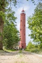 Liepaja, Latvia- July 5, 2023: Akmenraga Beacon lighthouse on a shore of Baltic sea. Road leading to lighthouse
