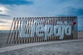 Liepaja city title at Baltic beach. Big letters on the beach by the sea during sunset