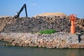 Liepaja, Latvia - May 31, 2011: Port with mole, lighthouse, logs and logging crane Royalty Free Stock Photo