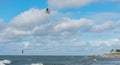 Liepaja, Latvia - September 29, 2019: Kiteboarder kitesurfer athlete performing jump in air while kitesurfing in sea. Blue, cloudy