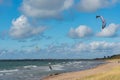 Liepaja, Latvia - September 29, 2019: Kiteboarder kitesurfer athlete performing kitesurfing in sea. Blue, cloudy sky