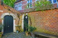 View on medieval old house front yard, red brick stone wall, green wood doors in ancient belgian village Royalty Free Stock Photo