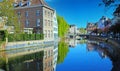 View over water town moat on medieval romantic old cityscape, ancient stone bridge, clear blue sky