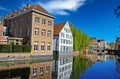 View over water town moat on medieval romantic old cityscape, ancient stone bridge, clear blue sky