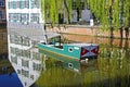 View on water moat with old traditional eel net fishing boat, medieval houses and weeping willow trees background