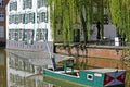 View on water moat with old traditional eel net fishing boat, medieval houses and weeping willow trees background