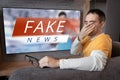Lies of tv propaganda mainstream media disinformation, A fake news report. viewer is watching TV and doesn`t believe in fake news