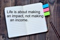 Life is abot making an impact, not making an income on notebook Royalty Free Stock Photo