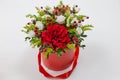 Life-affirming composition of fresh flowers Rose, Eustoma, Solidaga, Pistachio leaves and decorative berries in a scarlet cardbo Royalty Free Stock Photo