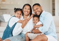 Life begins with family and ends with family. a young family happily bonding together on the sofa at home.