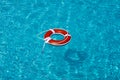 Life buoy in blue swimming pool. Lifebuoy pool ring float on blue water. Royalty Free Stock Photo