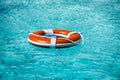 Life buoy in blue swimming pool. Lifebuoy pool ring float on blue water. Royalty Free Stock Photo