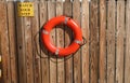 Life buoy hanging on wooden wall for emergency response when people sinking to water almost place near pool and beach Royalty Free Stock Photo