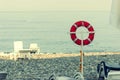 Life buoy on a pole on a beach with blue ocean water