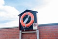 Life-buoy ring on the wooden pier and red brick wall Royalty Free Stock Photo