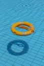 Life buoy in swimming pool. Summer vacation concept. Life ring floating on top of sunny blue water Royalty Free Stock Photo