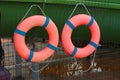 Life Buoys attached to green metallic grid photo