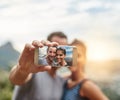 Life is a collection of memories. Portrait of a happy young couple taking selfies on a phone outdoors. Royalty Free Stock Photo