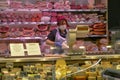 Daily life during coronavirus pandemic in Italy: saleswoman selling cheese and prosciutto with protective mask