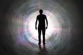 Life after death concept. Silhouette of man`s soul is walking to bright light - rays of god inside tunnel. Royalty Free Stock Photo