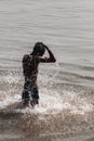 Life on the Ganges river. Young man in the river, throwing water on his head as purifying ritual. Spirituality