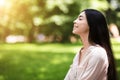 Portrait of relaxed asian girl breathing deeply with closed eyes in park