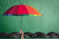 Life-health Insurance protection or business financial leadership concept with leader`s hand holding rainbow umbrella on green Royalty Free Stock Photo